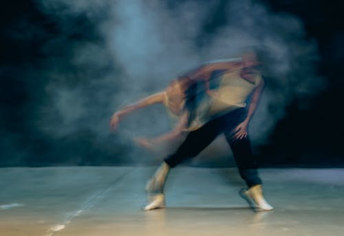 Two dancers are performing in a smokey room