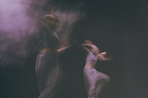 Two dancers in a foggy room with smoke