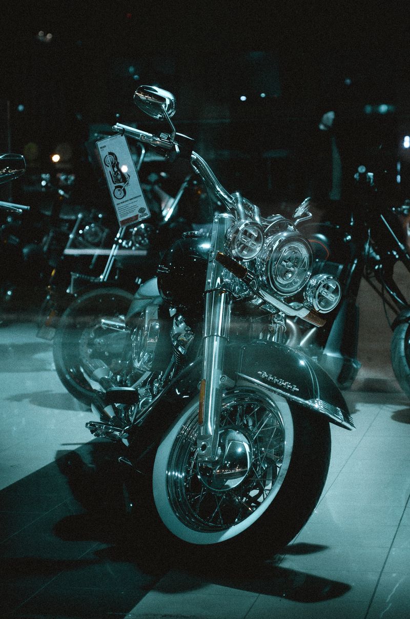 Elegant chrome motorcycle displayed indoors with dramatic lighting