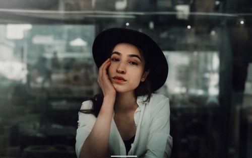 Free Portrait of a woman wearing a hat, posing thoughtfully in a cozy café in Istanbul. Stock Photo