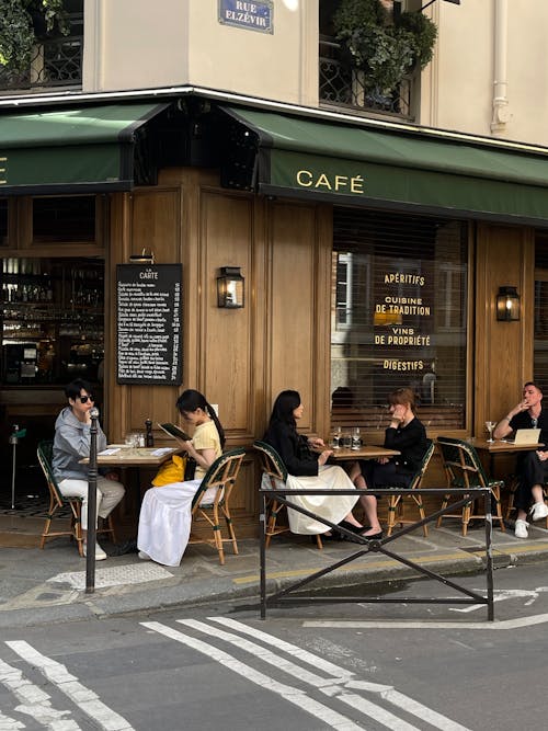 People sitting at tables outside a cafe