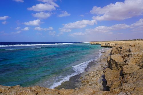 Free A beautiful coastline with turquoise water and rocky shore under a bright blue sky. Stock Photo