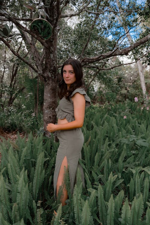 A woman in a green dress standing in a field