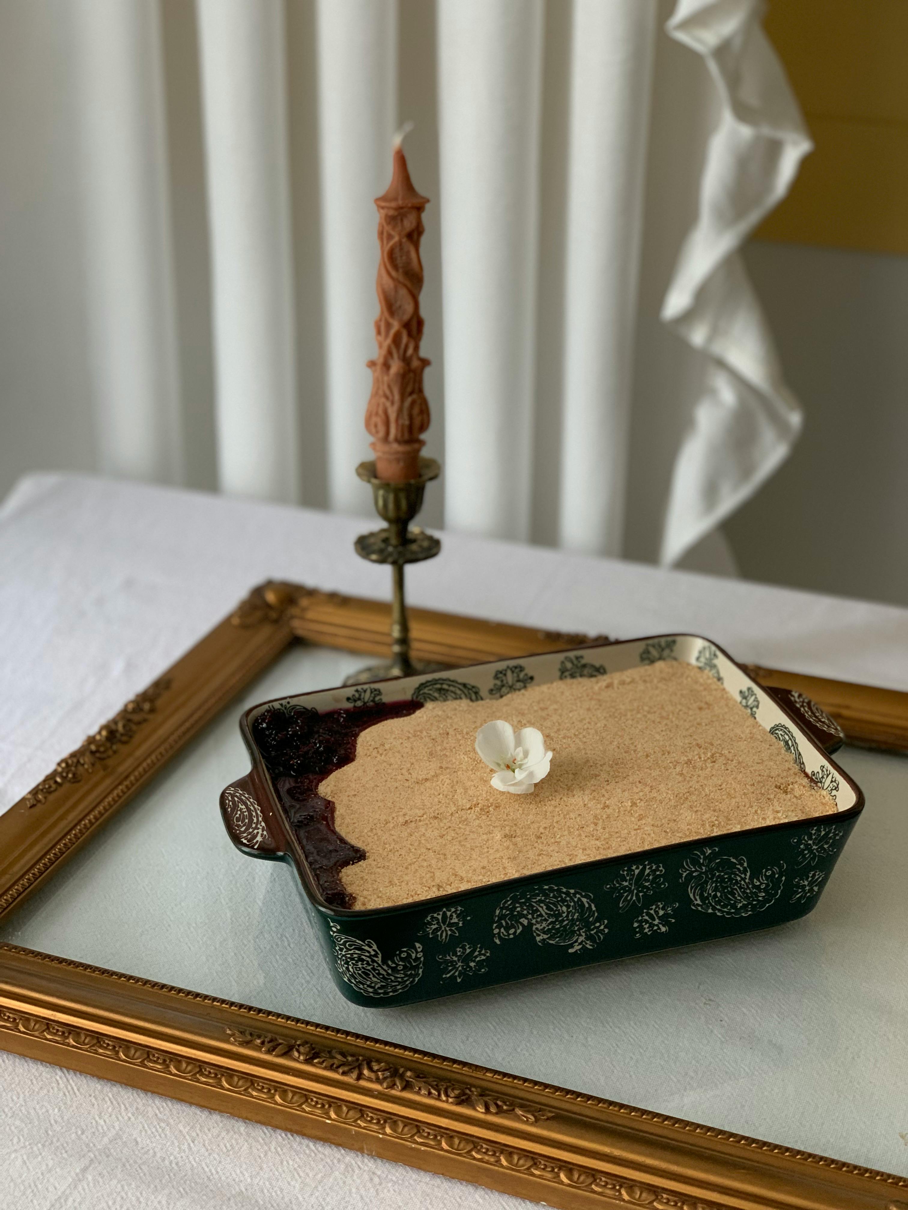 A beautifully styled dessert presented with a tall decorative candle, framed eloquently for sophistication.