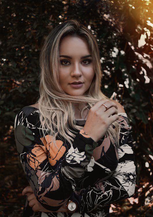 Woman Wearing Black, White, and Orange Long-sleeved Shirt Holding Her Blonde Hair