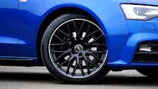 蓝色奥迪汽车轮辋与轮胎的详细特写，展现其设计与风格