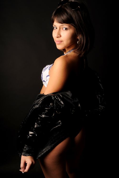 Free Model posing in a studio with a leather jacket and lingerie, exuding confidence. Stock Photo