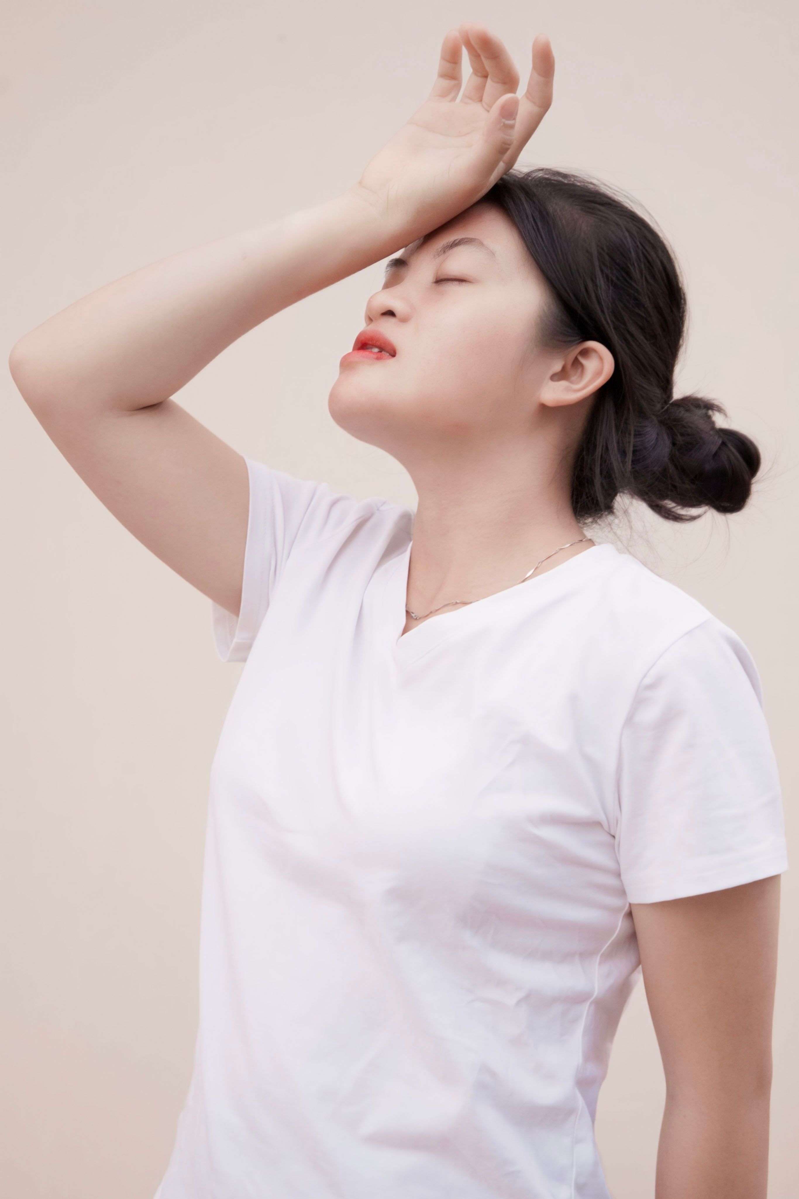 Young woman experiencing stress and fatigue, holding head in distress.