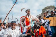 Vibrant African tribal festival with men on horseback and traditional attire.
