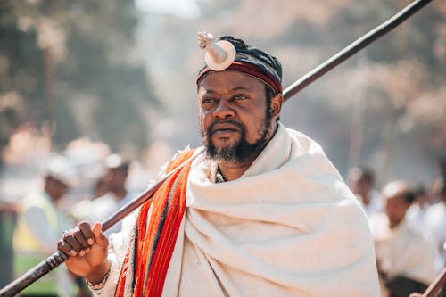 A man in traditional clothing holding a spear