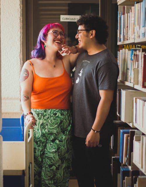 A couple standing in front of bookshelves in a library