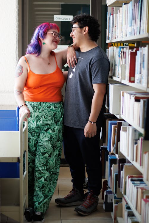 A man and woman standing in a library with books