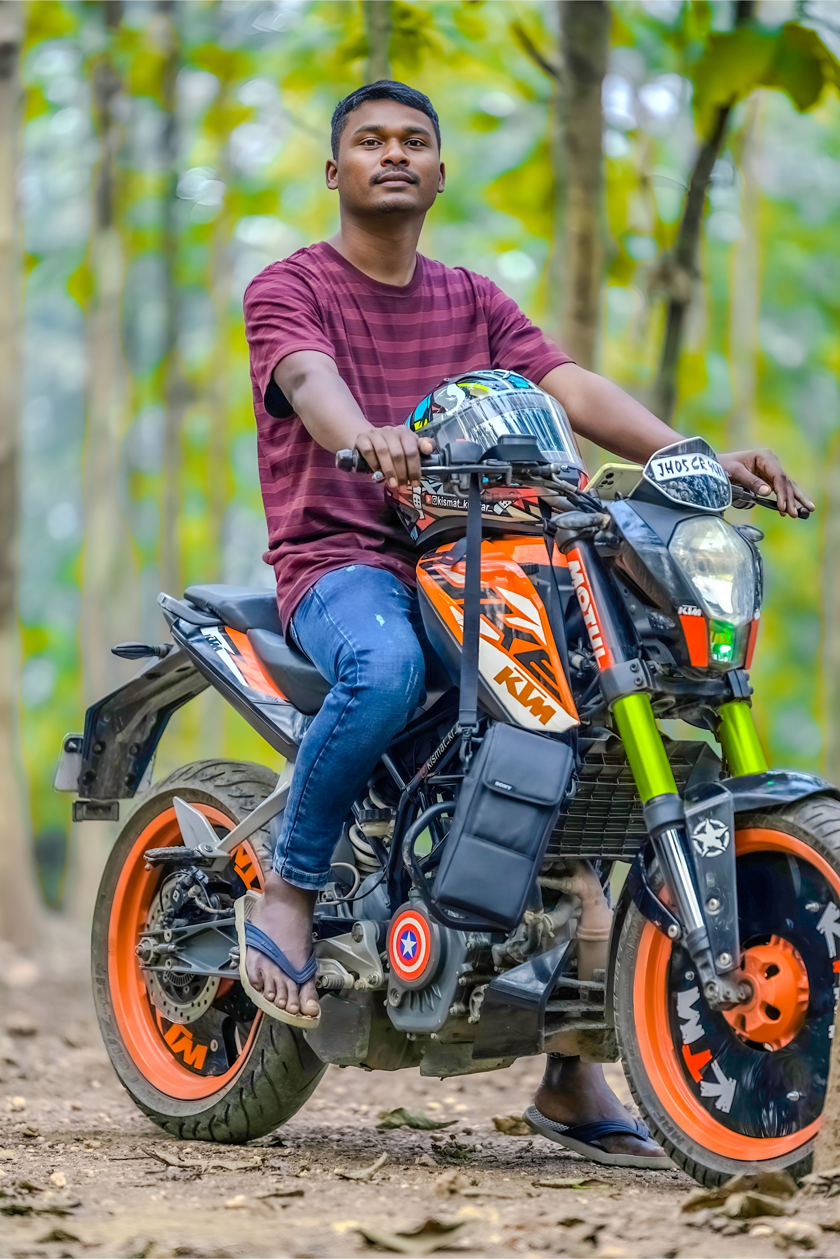 Man posing on KTM motorcycle in a forest. Perfect for adventure and travel themes.