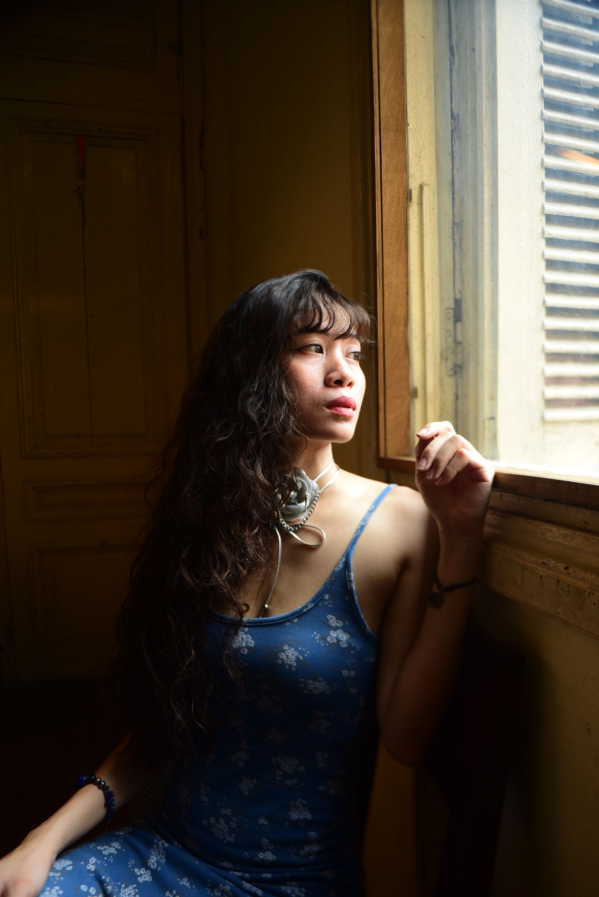 Young Woman in a Floral Blue Dress Sitting by the Window · Free Stock Photo