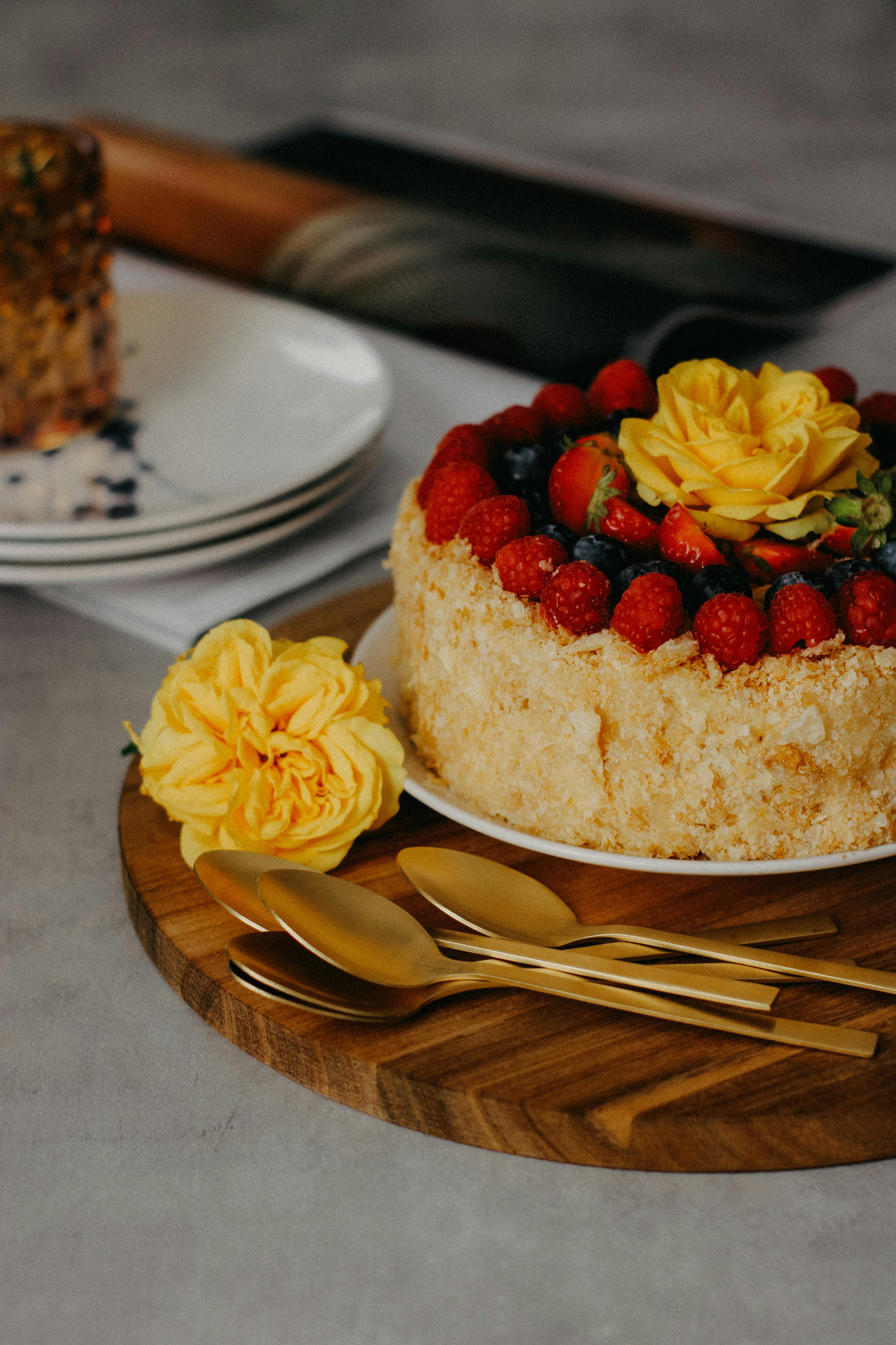 A beautiful berry layer cake adorned with vibrant yellow roses, perfect for dessert lovers.