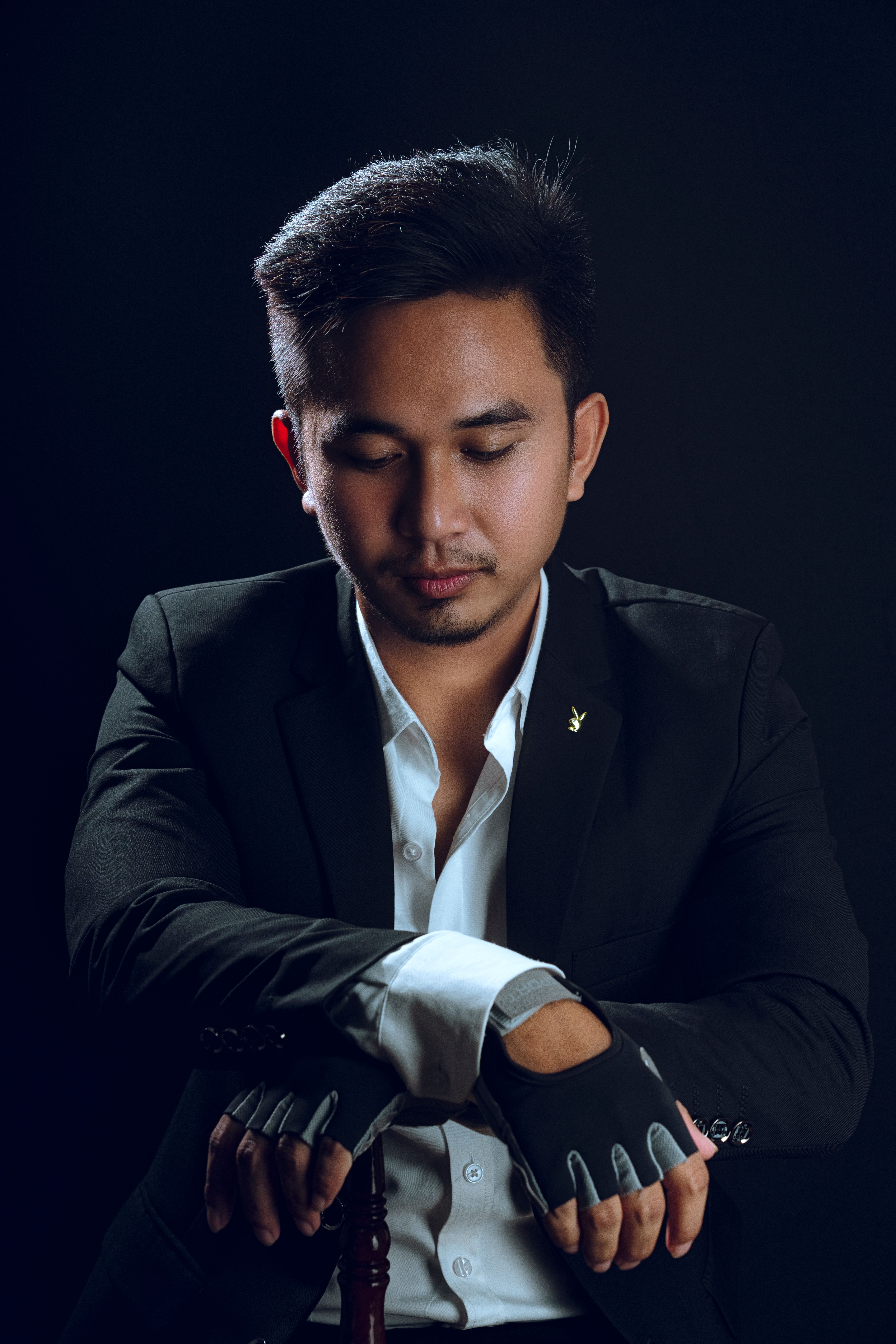 A man in a suit and tie is holding his wrist · Free Stock Photo