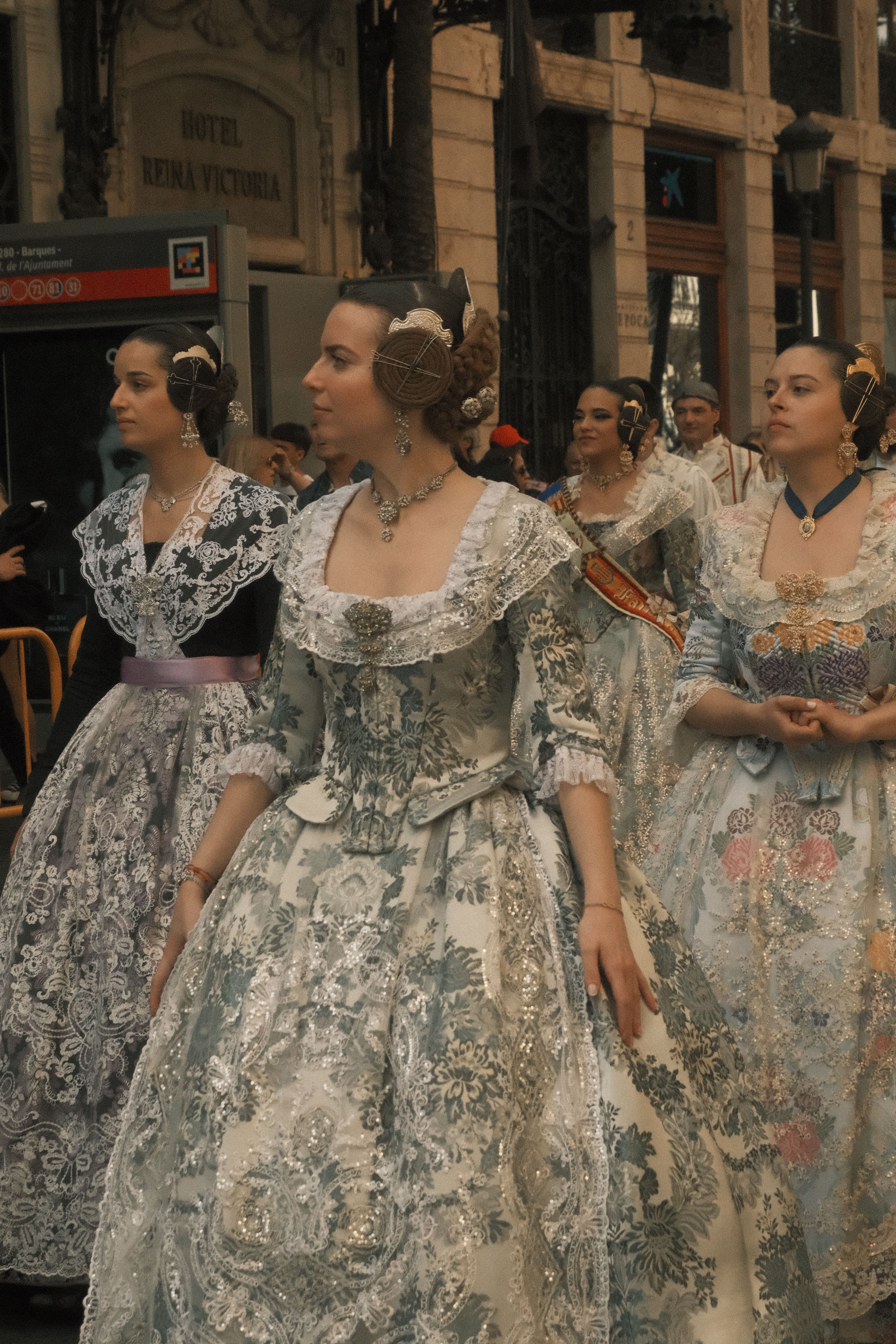 Women in intricate traditional dresses participate in a Spanish cultural parade.