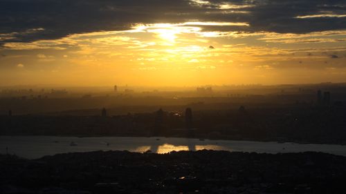 Free Stunning aerial view of a city skyline silhouetted against a vibrant sunset. Stock Photo