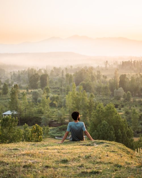 Free A man enjoys the tranquil beauty of the green countryside in Srinagar during a serene morning. Stock Photo