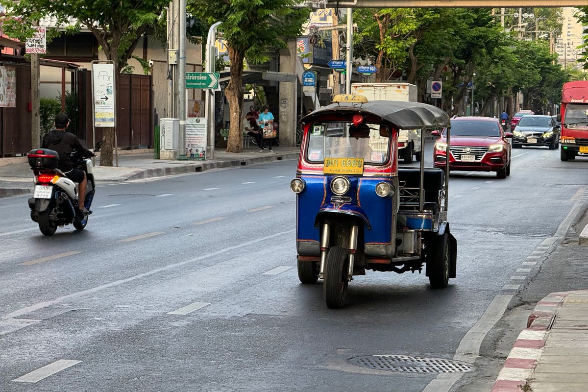 Tuk-tuk waiting for passengers on a Bangkok street, a common tourist-trap transport option in Southeast Asia
