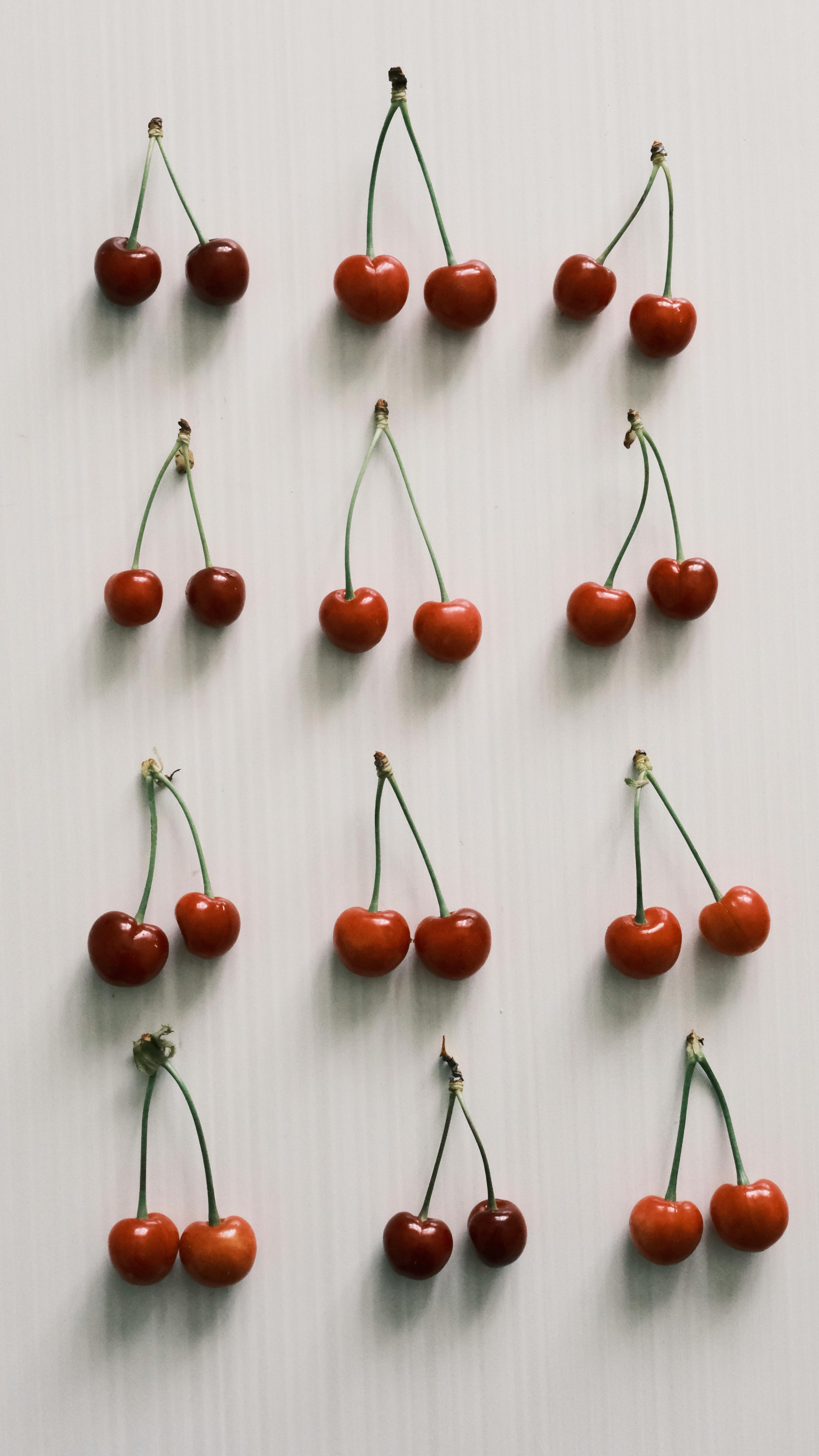 Aesthetic display of red cherries on a white background, ideal for food photography.