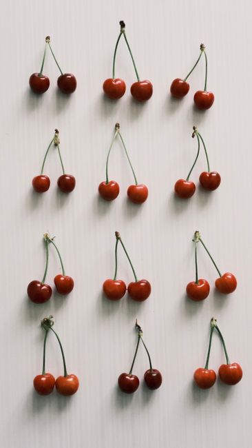 Aesthetic display of red cherries on a white background, ideal for food photography.