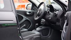 通过敞开的门，可以看到汽车内饰光滑的方向盘和仪表板