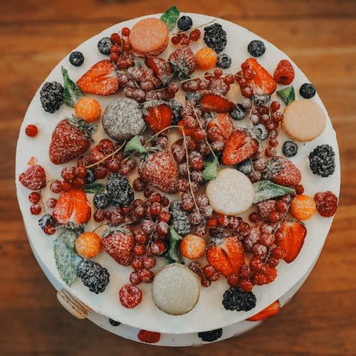 A cake with fruit on top is on a wooden table