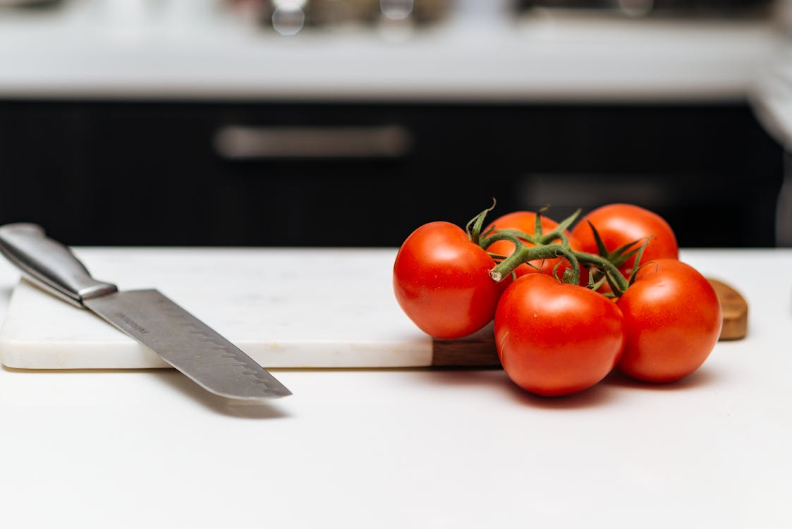 Five Tomatoes on Chopping Board