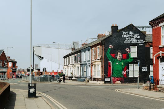 Street view in Liverpool, UK, featuring a famous soccer mural on a building wall.