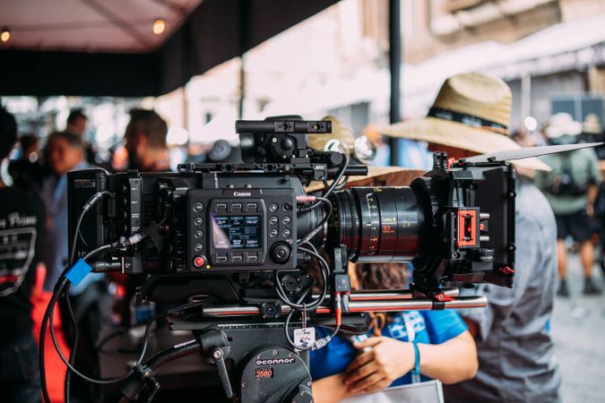 Close-up of a professional video camera setup at an outdoor event focusing on filmmaking equipment.