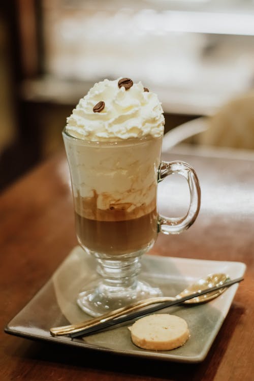 A coffee drink with whipped cream and cookies