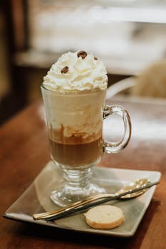 Luxurious mocha topped with whipped cream and coffee beans on a wooden table.