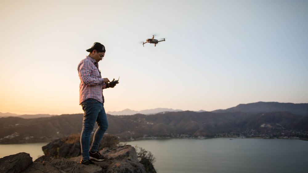 Cloudline Aerial pilots preparing a drone beside a lake at sunset