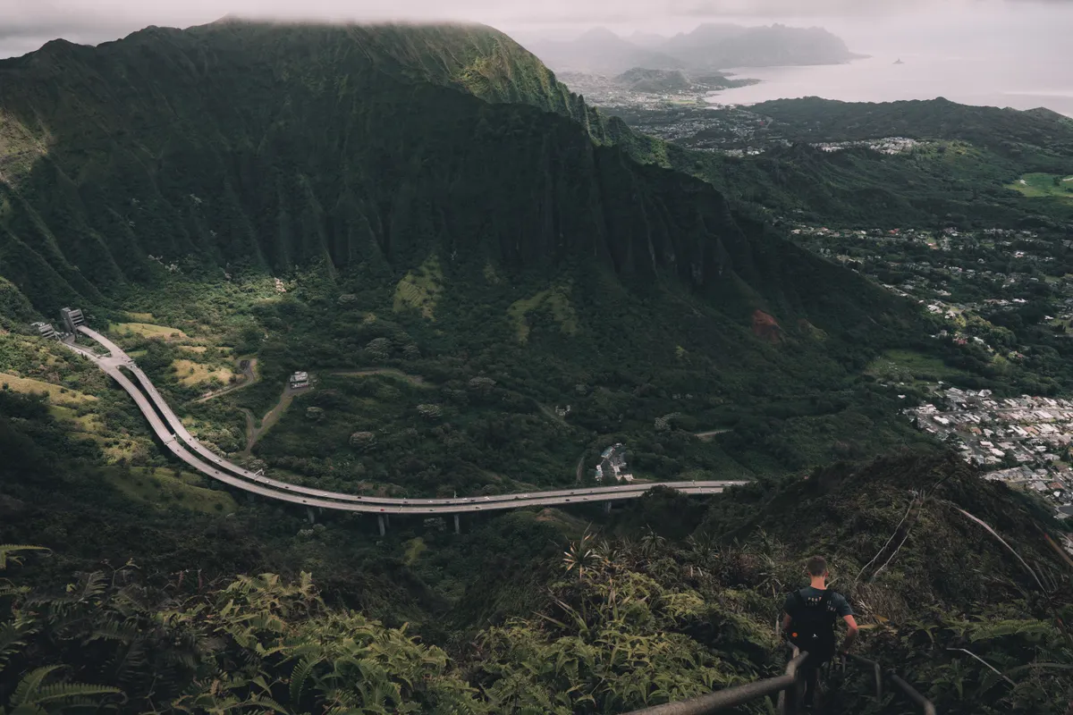 Lush green Oahu mountains with a winding road through the valley