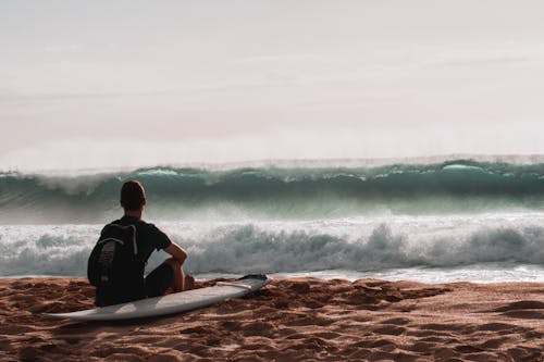 Free Person Sitting At The Beach With Surfboard Stock Photo