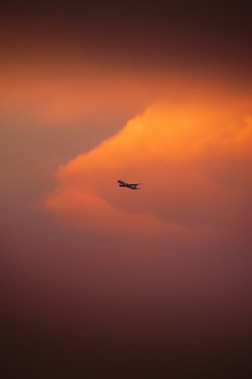 A plane flying through a cloudy sky