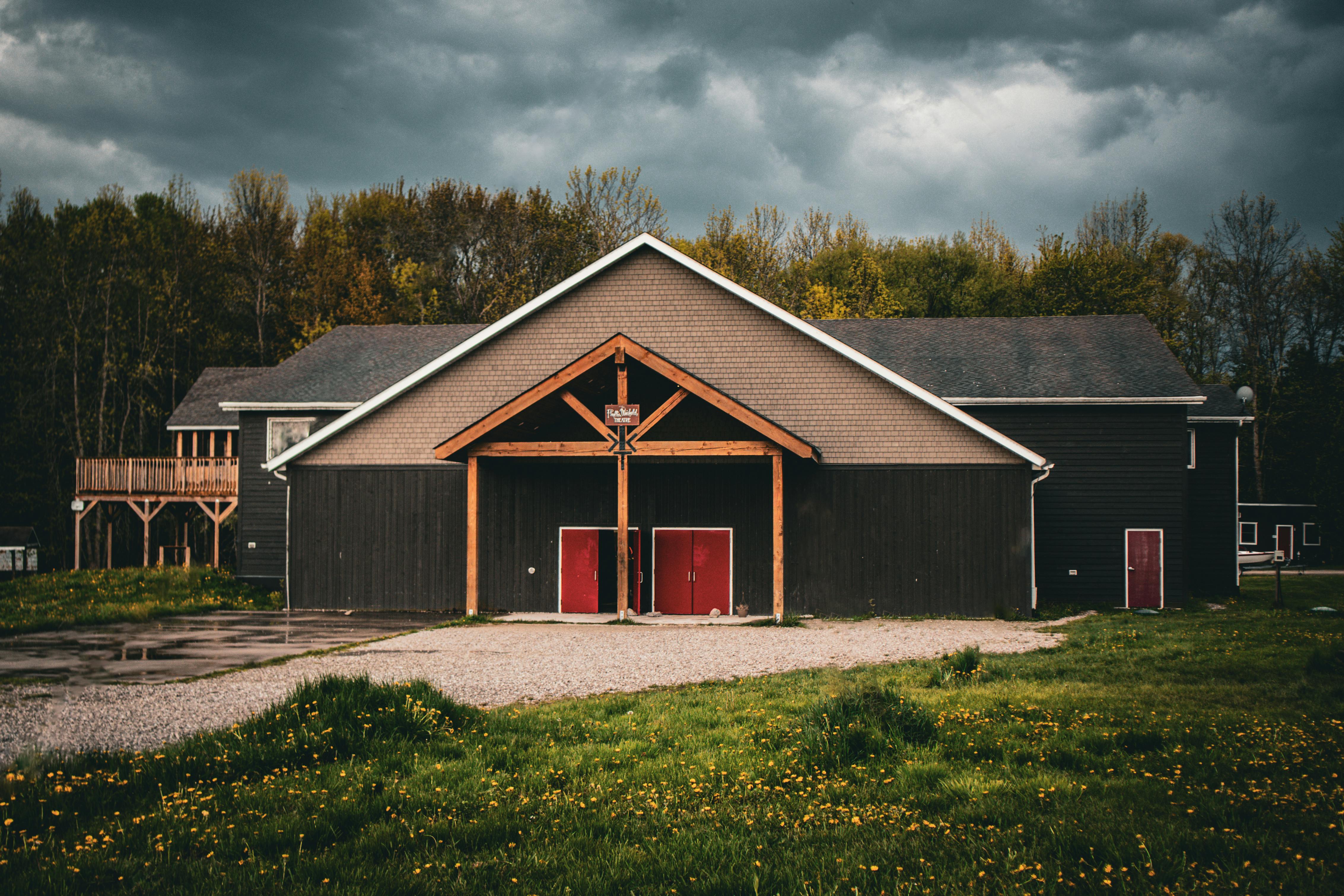 A rustic barn set against a forest backdrop under cloudy skies in Orillia, Ontario.
