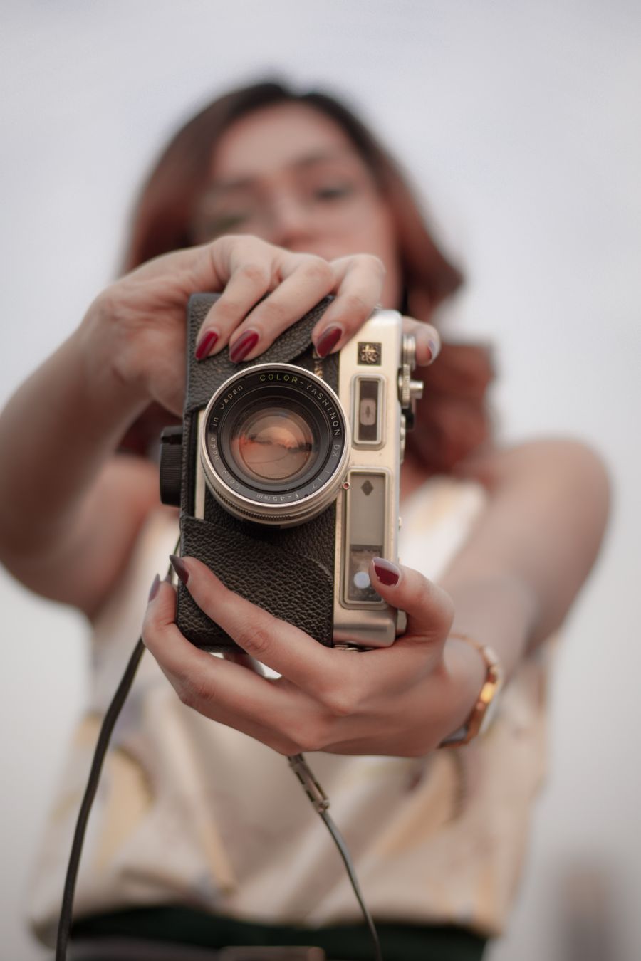 Fotografka drží v rukou starožitný fotoaparát
