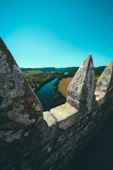 从石城垛上俯瞰，蜿蜒的河流与清澈蓝天下郁郁葱葱的风景尽收眼底