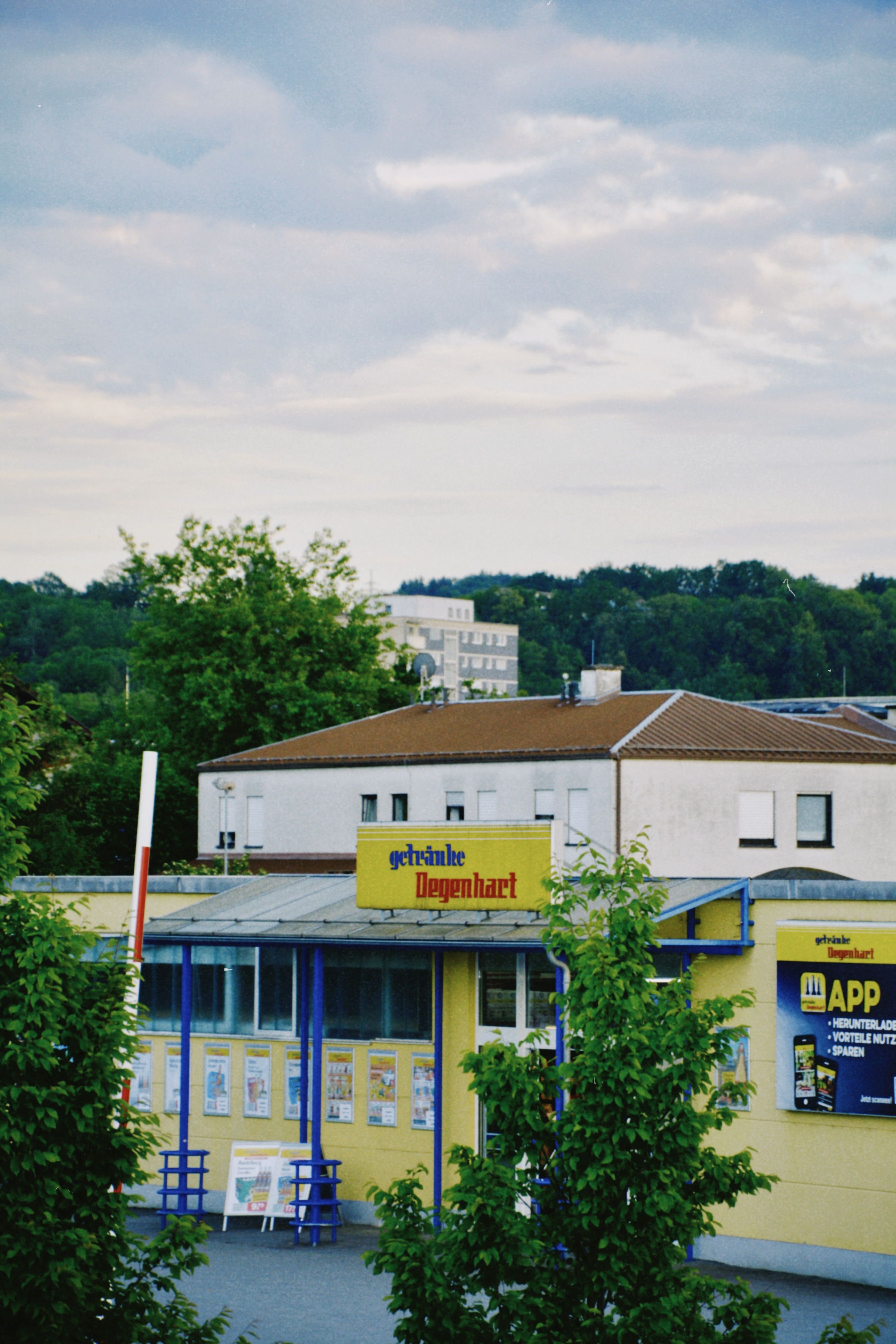 Retail store exterior in Deggendorf, Germany with urban landscape background.