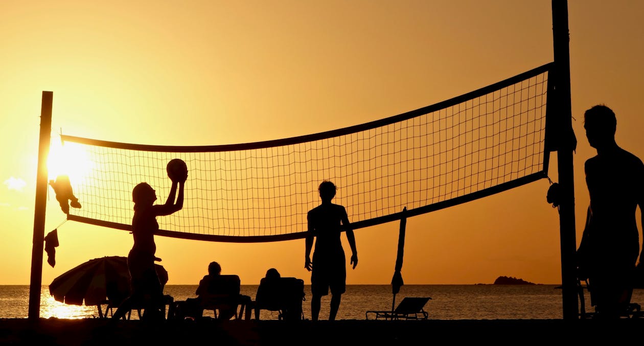 friends playing volleyball at the beach
