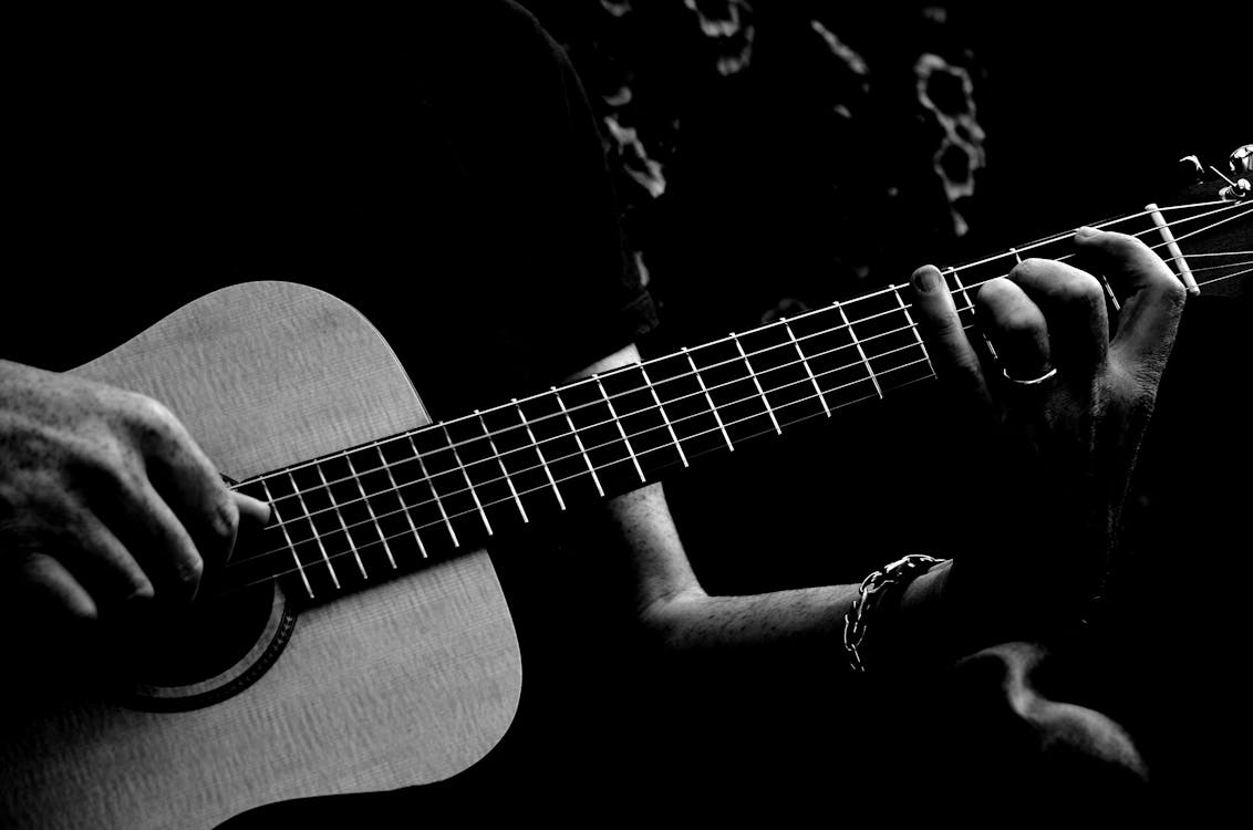 アコースティックギターを弾く人のモノクロ写真 無料の写真素材