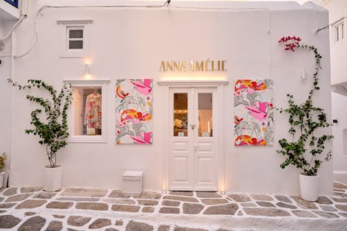 A white building with pink flowers and a sign that says anne marie