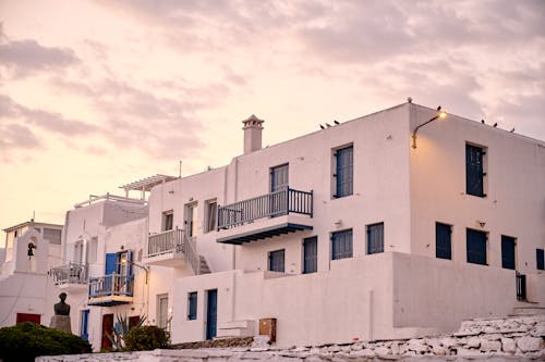 A white building with blue shutters and balconies