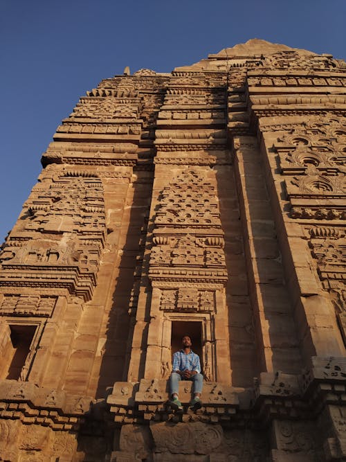 ブルートップの男とコンクリートの建物に座っているジーンズ