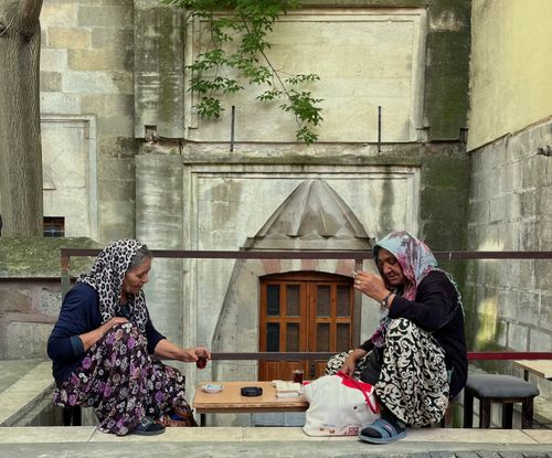 Free Two women enjoy tea outdoors in Edirne, Türkiye, capturing a slice of urban life. Stock Photo