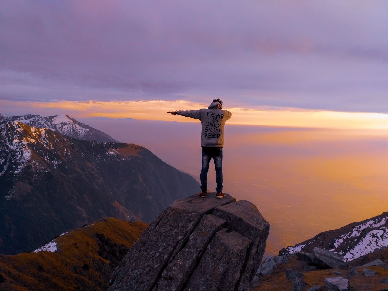 a lone hiker stands triumphantly on a rock embracing the serene dawn o