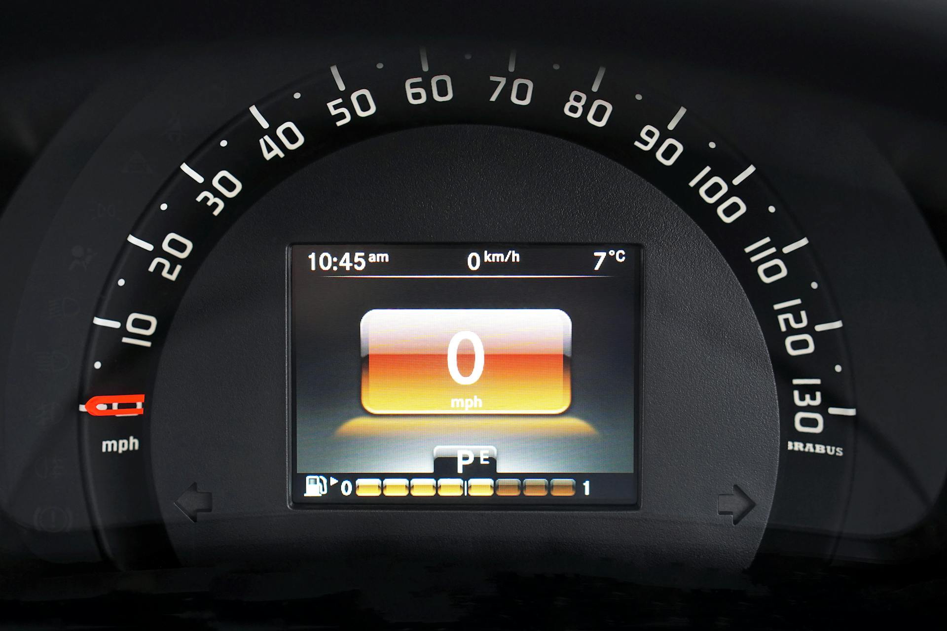 Close-up of a luxury car dashboard with a digital speedometer and sleek design features.