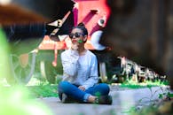 白天，一位穿着休闲装的年轻女子在老式火车旁若有所思地摆着姿势